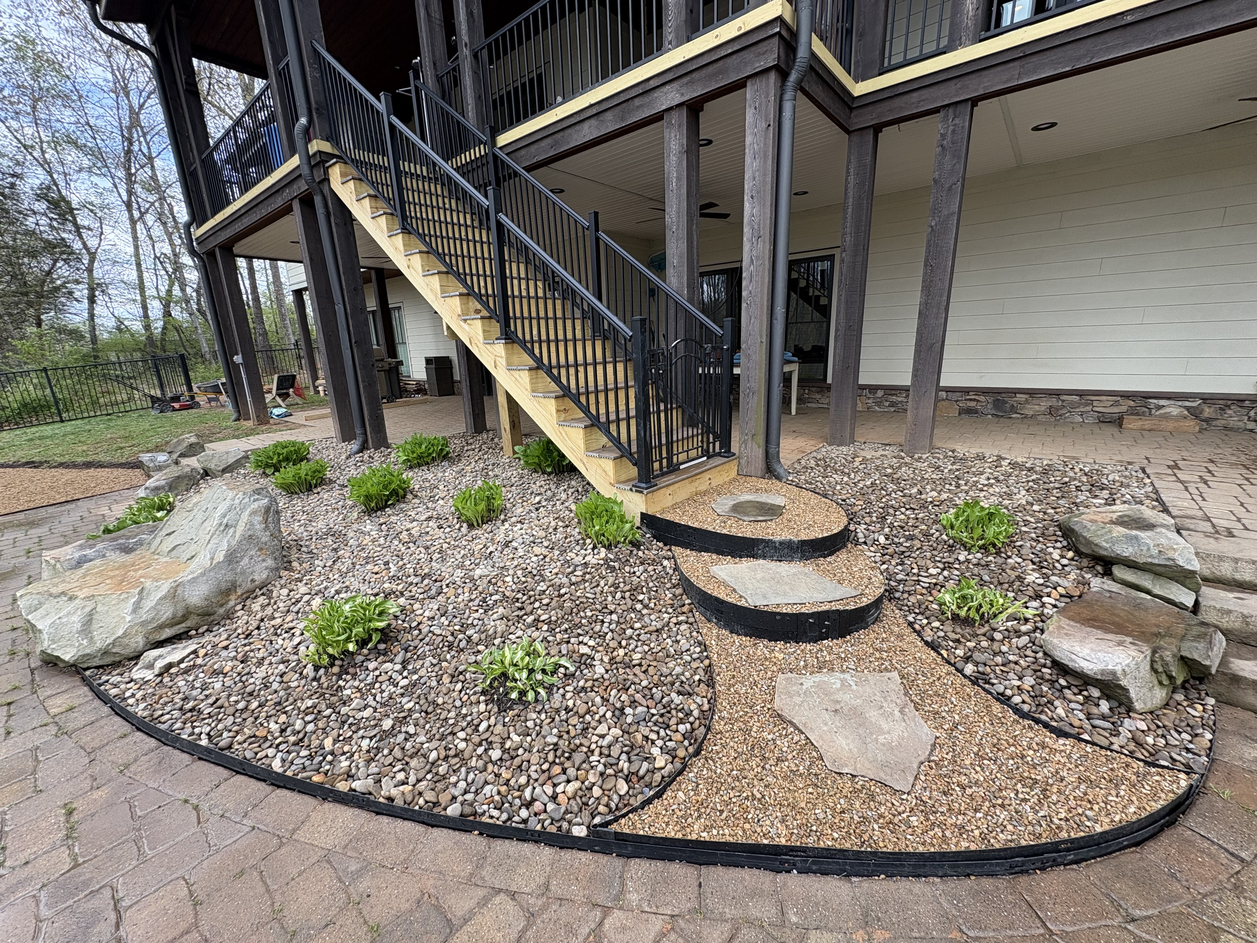 River rock landscaping with plantings and stepping stones